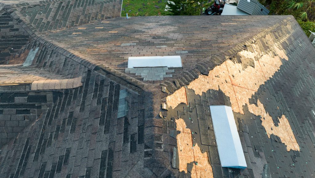 Old, weathered, and missing asphalt shingles on a home's roof.