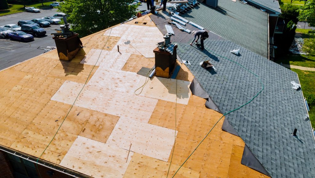 Professional roofers replace a full asphalt shingle roof.