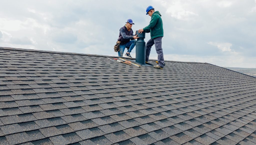 Roofers inspecting a chimney and the flashing around it.