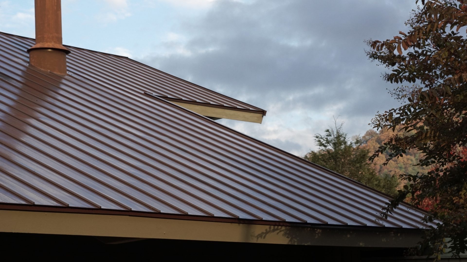 A close-up of a roof with a brown standing seam steel roof.