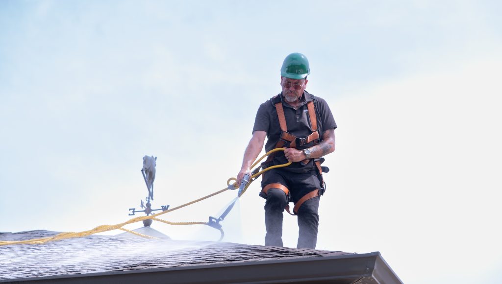 A professional roofer and Roof Maxx dealer applies the all-natural, oil-based restoration treatment to a residential roof.