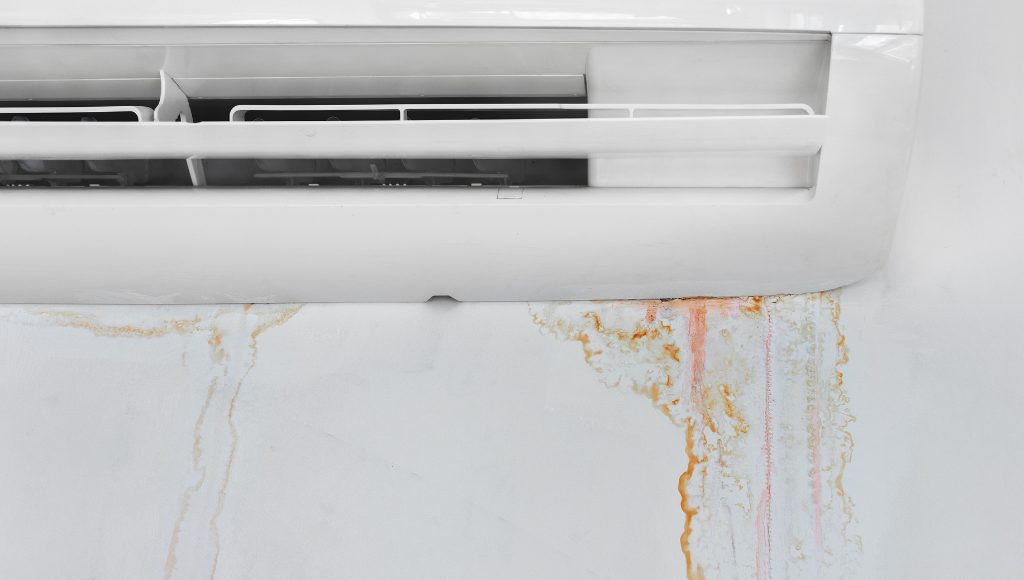 A heat pump inside a home leaks around the edges, creating water damage to walls.