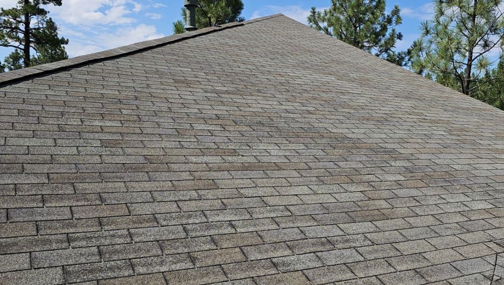 Asphalt shingles on a residential Northern Arizona roof that have begun to dry and lose some of their granules from elevated UV exposure.