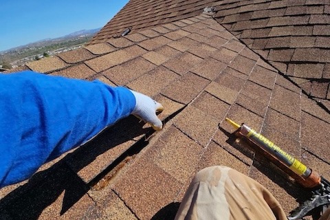 Asphalt shingles curling and lifting from age and UV damage